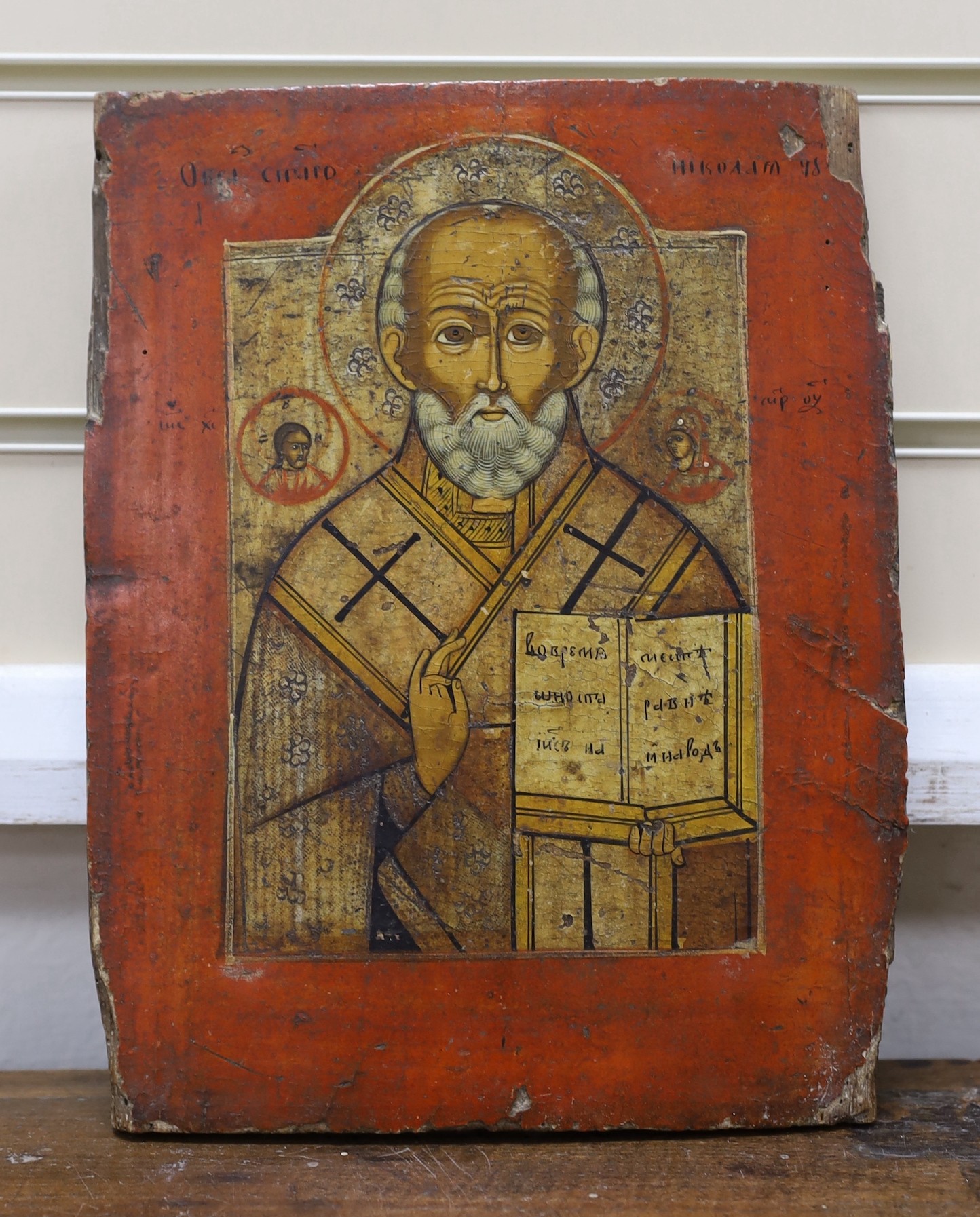 19th century South Russian School, tempera on wooden panel, Icon of St. Nicholas holding the scripture and giving a benediction, 28 x 22cm, unframed